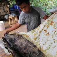 Ein Handwerker bedruckt in Indonesien Ökotextilien: Faire und umweltfreundliche Praktiken sind in der Textilbranche weltweit noch nicht an der Regel.