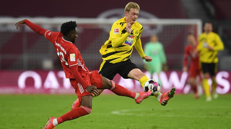 Stellvertretend für eine intensive Partie: Bayerns Alphonso Davies (l.) und Dortmunds Julian Brandt gehen ohne Rücksicht auf Verluste zum Ball.