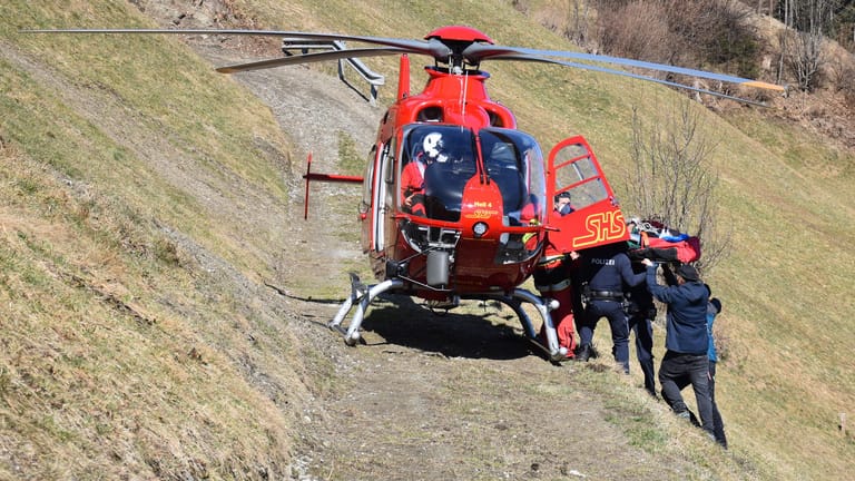 Österreich, Mayrhofen: Ein verunglückter Gleitschirmpilot wird in einen Hubschrauber gehoben, um ins Krankenhaus nach Innsbruck transportiert zu werden.