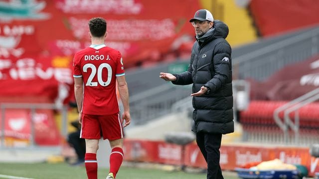 Liverpool-Trainer Jürgen Klopp (r) spricht an der Seitenlinie mit Diogo Jota.