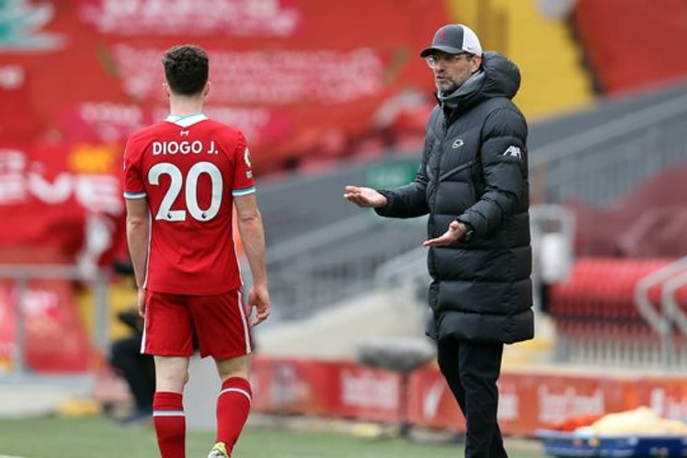 Liverpool-Trainer Jürgen Klopp (r) spricht an der Seitenlinie mit Diogo Jota.
