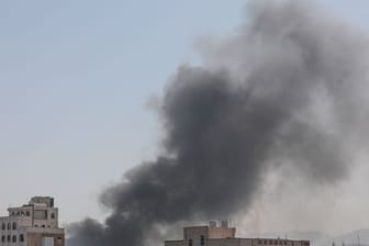 Schwarzer Rauch steigt in Sanaa zwischen Gebäuden auf.