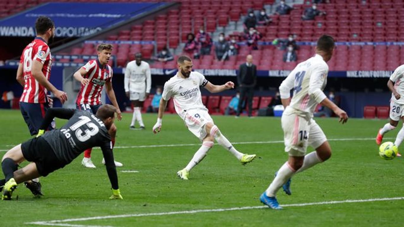 Real Madrids Karim Benzema (M) schießt das Tor zum 1:1-Endstand im Lokal-Derby von Madrid.