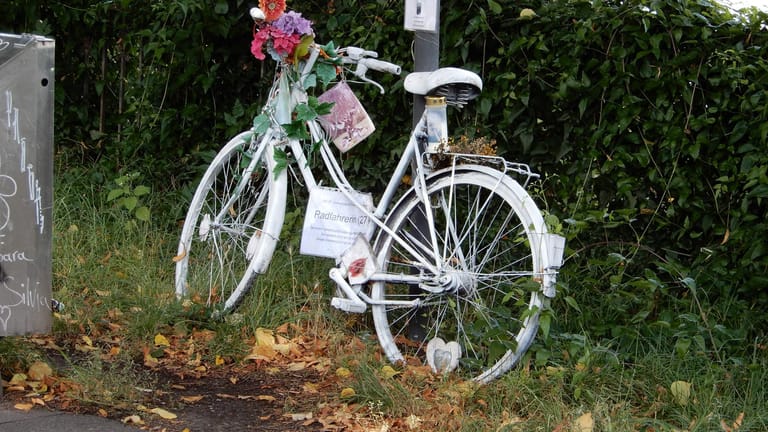 Ein weiß angemaltes Fahrrad steht am Straßenrand in Köln: Die sogenannten Ghost Bikes werden als Mahnmale für tödlich verunglückte Radler am Unfallort aufgestellt.