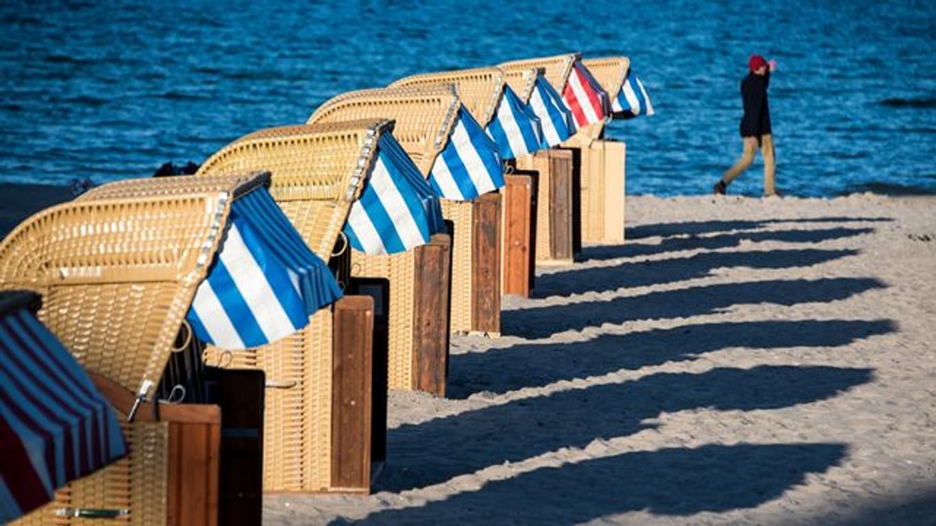 Strandkörbe werfen am Abend lange Schatten auf den Strand an der Ostsee bei Lübeck-Travemünde (Archivfoto): Ministerpräsident Günther zeigt sich optimistisch, was den Tourismus in Schleswig-Holstein an Ostern angeht.