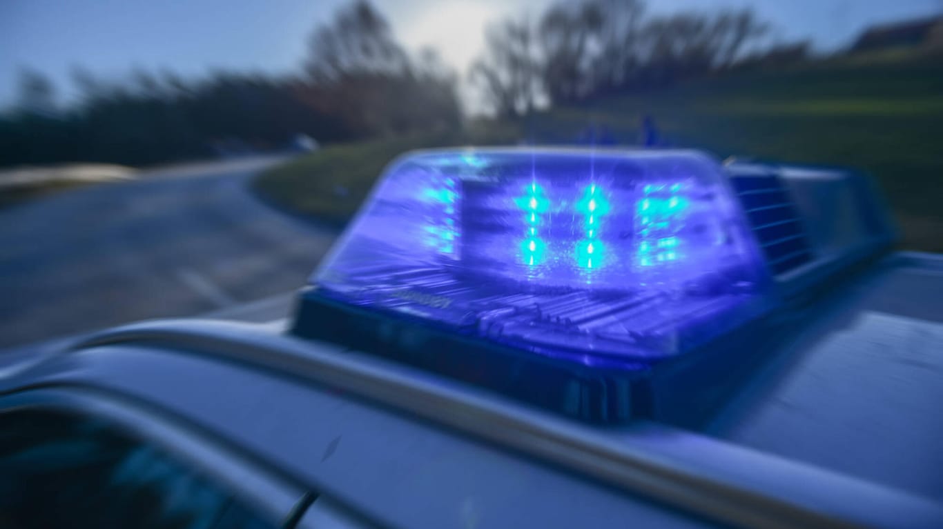 Polizeiwagen mit Blaulicht (Symbolbild): Ein Mann ist bei voller Fahrt auf der Autobahn aus einem Wagen gestürzt.