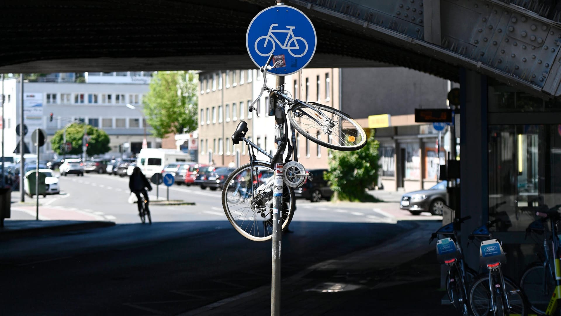 Ein Fahrrad hängt an einem Straßenschild in Köln: Das bereits 2016 vorgestellte Innenstadtkonzept für bessere Radwege wurde bisher noch nicht umgesetzt.