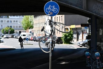 Ein Fahrrad hängt an einem Straßenschild in Köln: Das bereits 2016 vorgestellte Innenstadtkonzept für bessere Radwege wurde bisher noch nicht umgesetzt.