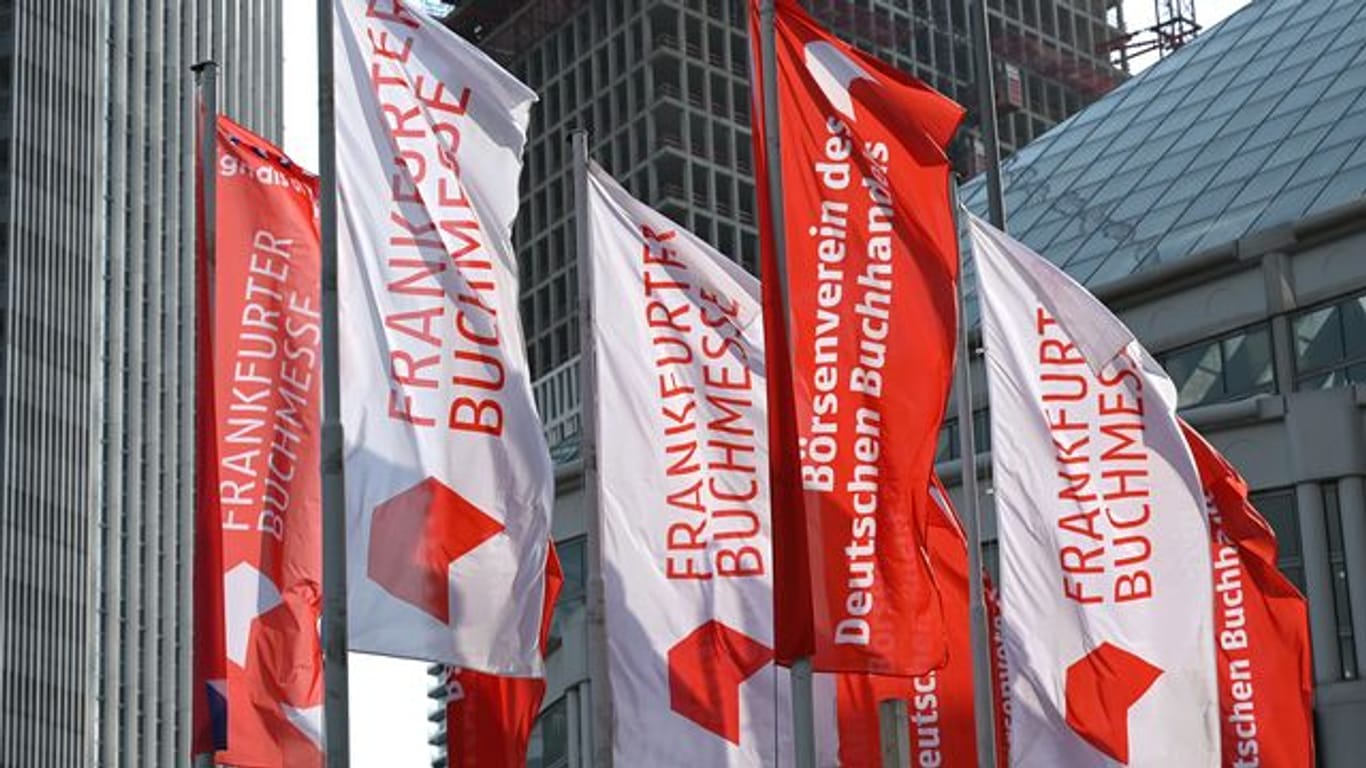 Fahnen von "Frankfurter Buchmesse" und "Börsenverein des Deutschen Buchhandels" vor dem Messegelände (Archivbild): Die Buchmesse soll dieses Jahr wieder als Präsenzveranstaltung stattfinden.