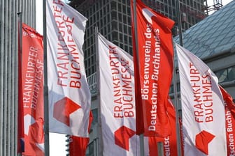 Fahnen von "Frankfurter Buchmesse" und "Börsenverein des Deutschen Buchhandels" vor dem Messegelände (Archivbild): Die Buchmesse soll dieses Jahr wieder als Präsenzveranstaltung stattfinden.