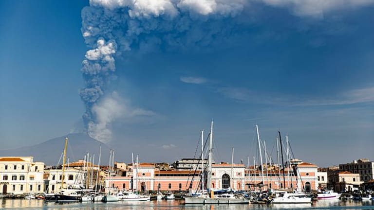 Rauchschwaden aus dem Krater des Vulkans Ätna steigen im Hintergrund von Catania auf.