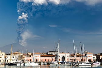 Rauchschwaden aus dem Krater des Vulkans Ätna steigen im Hintergrund von Catania auf.