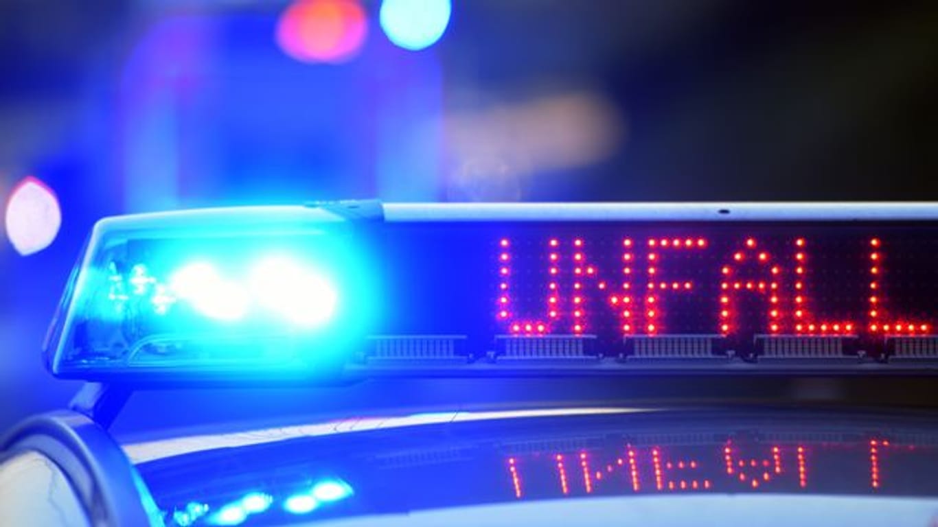 Ein Polizeiwagen steht mit eingeschaltetem Blaulicht an einem Unfallort (Symbolbild): Auf der Autobahn bei München ist ein Lastwagen umgekippt.