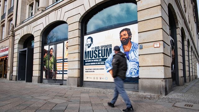 Ein Mann geht an einer Hausfassade vorbei, in deren Fenster Zeichnungen von Bud Spencer, zu sehen sind: Berlin bekommt ein Bud-Spencer-Museum.