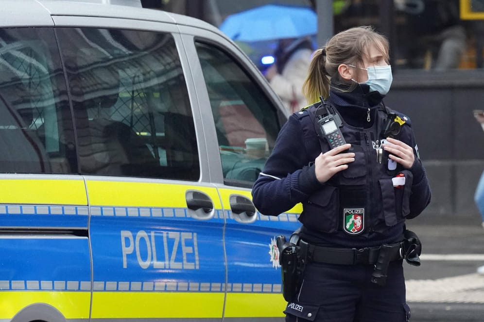 Eine Polizistin mit Mundschutz steht in der Kölner Innenstadt (Archivbild): Die Polizei hat am Montag ihre Kriminalstatistik veröffentlicht.