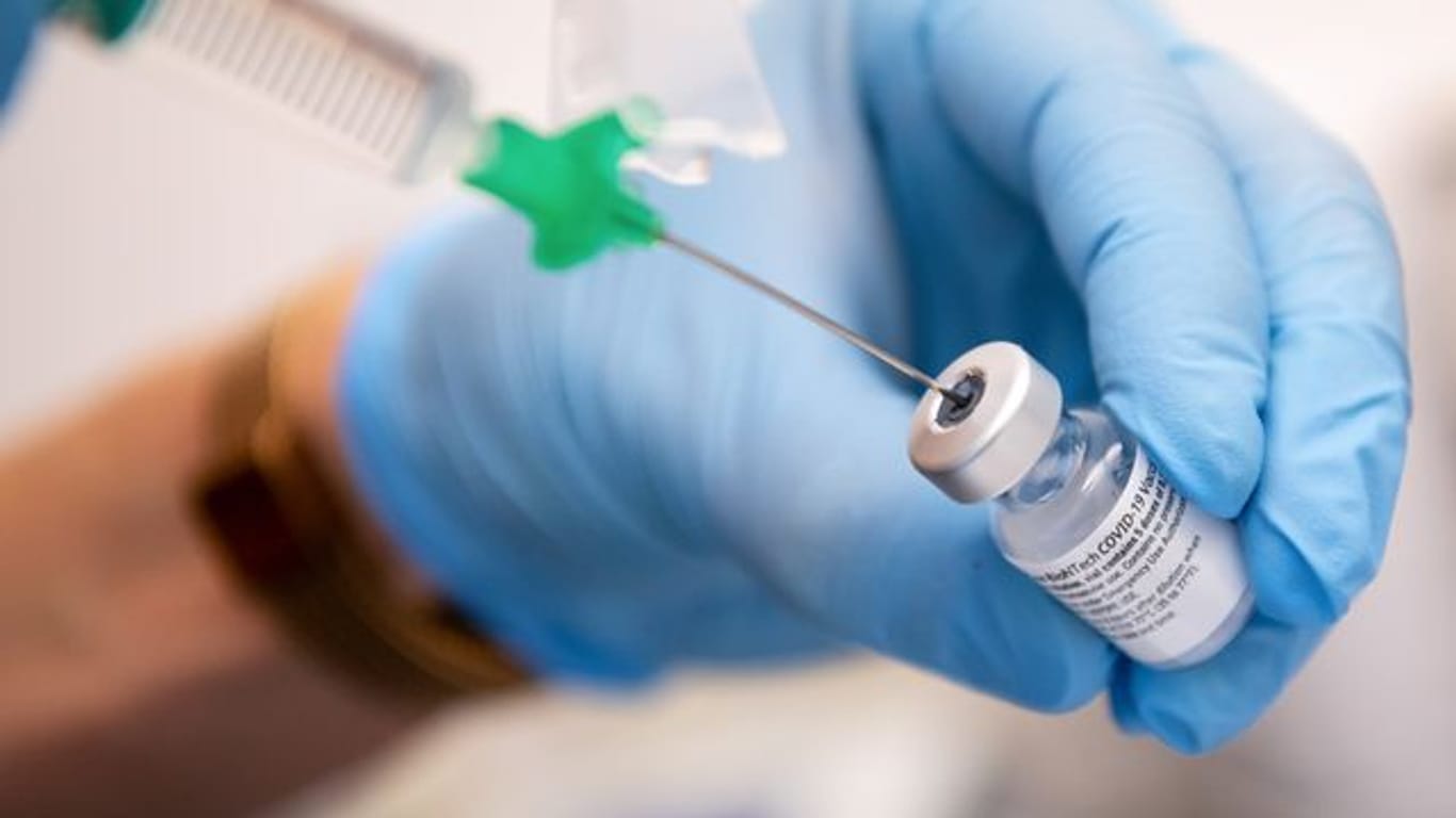 Eine Klinik-Mitarbeiterin zieht eine Spritze mit einem Covid-19 Impfstoff auf (Archivbild): Die bayerischen Impfzentren sind noch immer nicht ausgelastet.