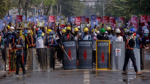 Anti-Coup-Demonstranten mit behelfsmäßigen Schilden beziehen bei einem Protest in Yangon Stellung. Anti-Coup-Demonstranten mit behelfsmäßigen Schilden beziehen bei einem Protest in Yangon Stellung.