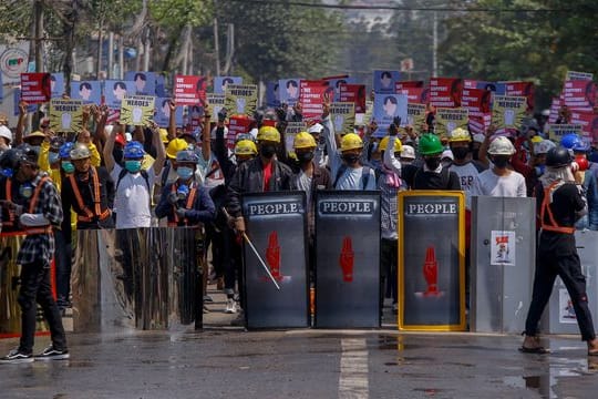 Anti-Coup-Demonstranten mit behelfsmäßigen Schilden beziehen bei einem Protest in Yangon Stellung.