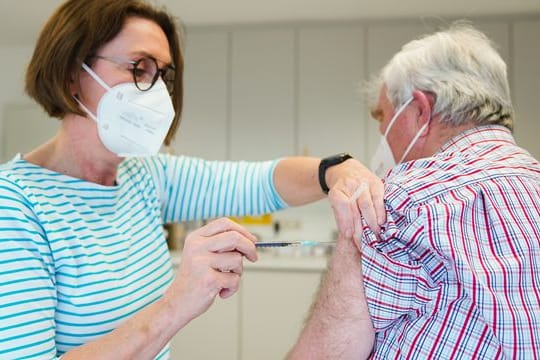 Eine Hausärztin verabreicht in Naila einem Patienten eine Impfung gegen Covid-19.