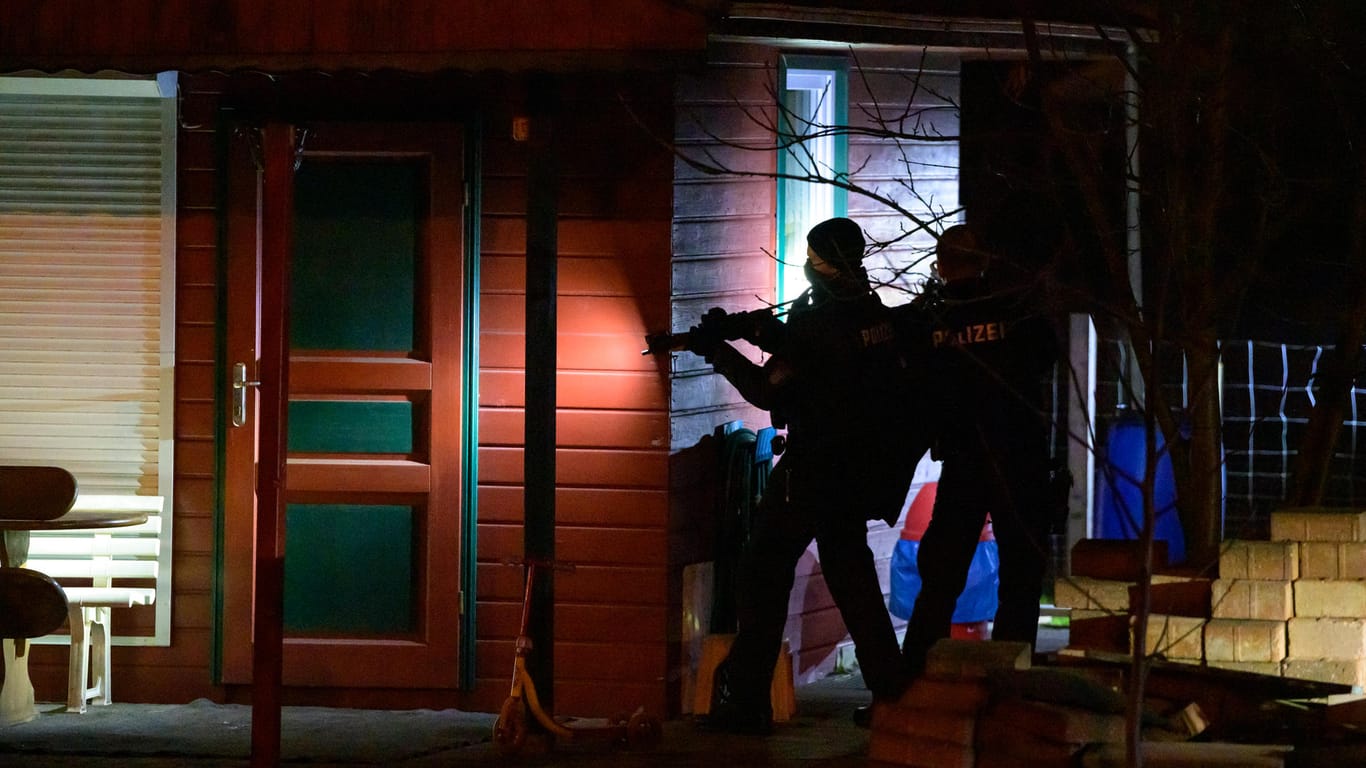 Polizisten der Beweis- und Festnahmeeinheit (BFE) durchsuchen mit gezogenen Maschinenpistolen einen Kleingartenverein: Die Polizei war mit einem Großaufgebot im Einsatz.