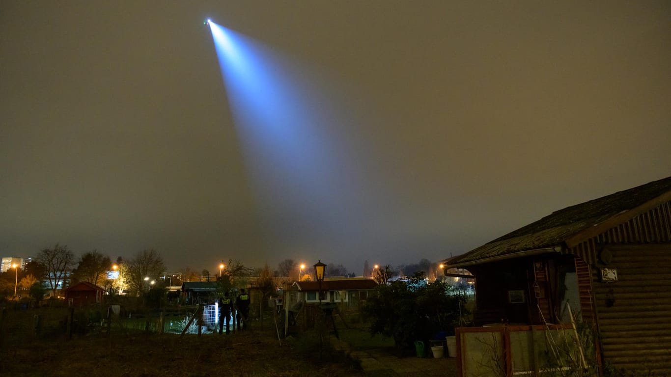 Der Polizei-Helikopter Libelle leuchtet mit seinem Suchscheinwerfer in einen Kleingartenverein: Laboruntersuchungen sollen Vorfall aufklären.