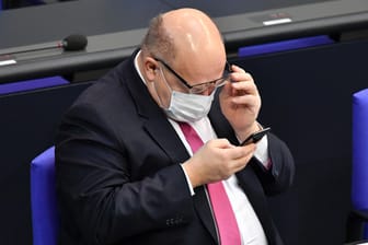 Ein tiefer Blick ins Handy: Wirtschaftsminister Peter Altmaier muss Betrüger bei den Corona-Hilfen aufspüren.