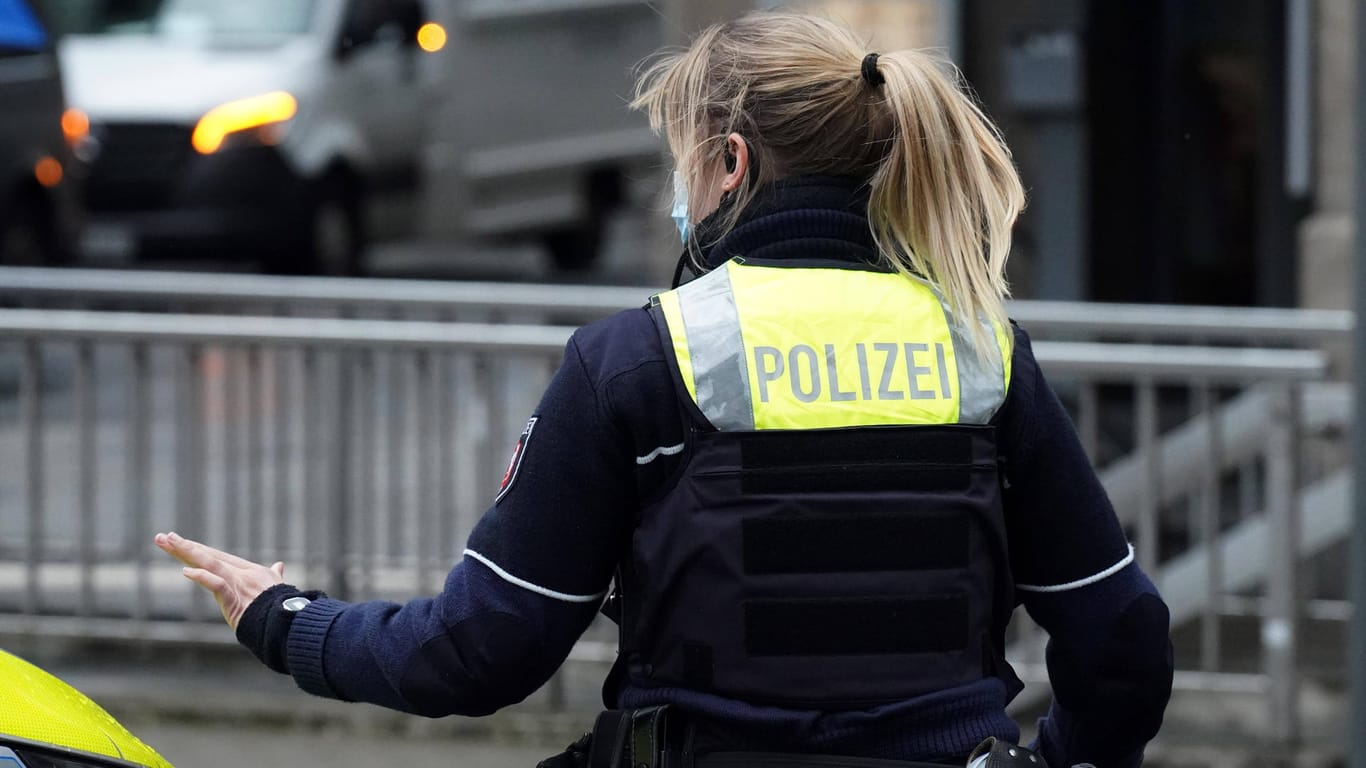 Polizistin kontrolliert Auto (Archivbild): Die Kölner Polizei führt im Norden der Stadt Personen- und Fahrzeugkontrollen durch.