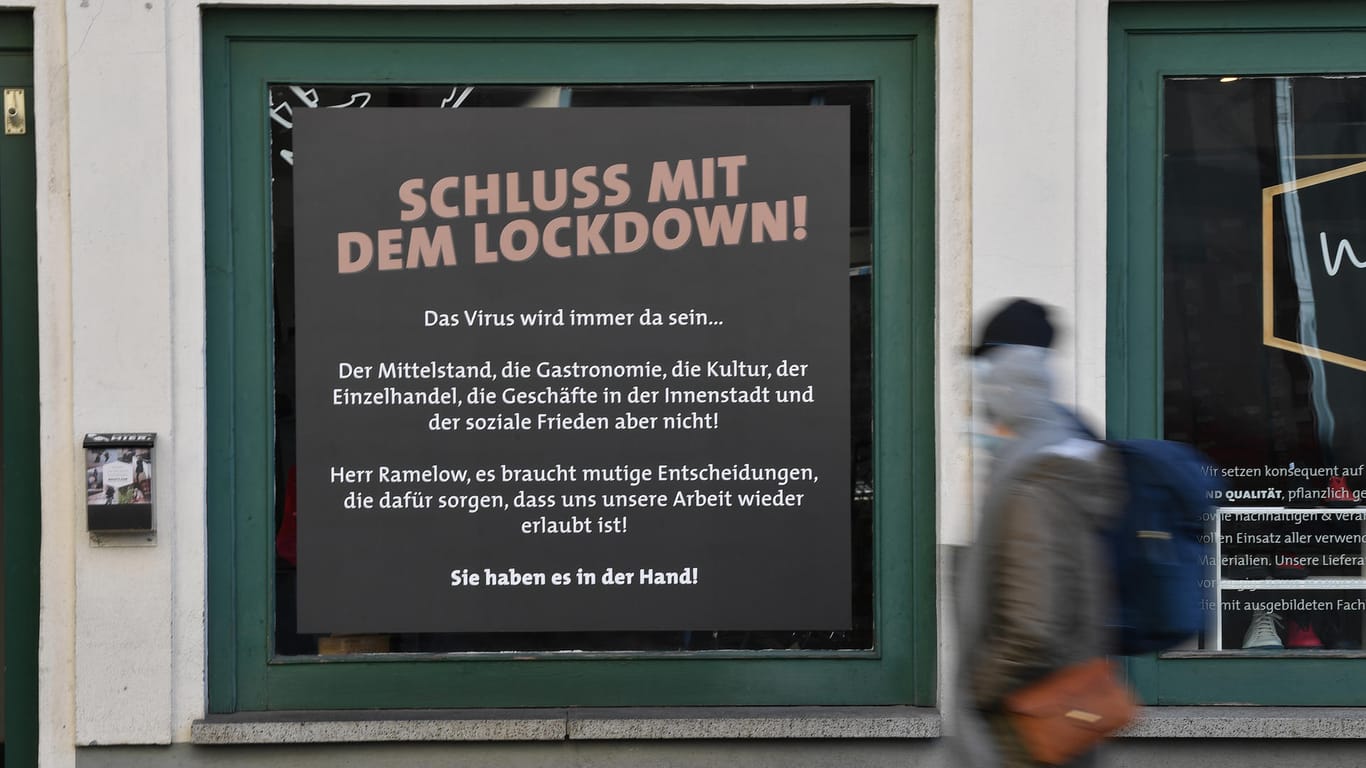 "Schluss mit dem Lockdown!" steht auf dem Plakat an einem Schaufenster in der Altstadt: Kosten und Nutzen des Erfurter Experiments stehen nach Ansicht von Weimars OB Kleine in keinem Verhältnis.