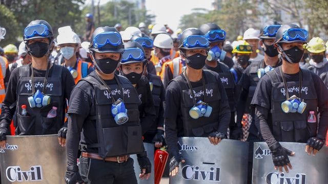 Anti-Coup-Demonstranten mit behelfsmäßigen Schilden beziehen bei einem Protest gegen den Putsch der Militärjunta Stellung. Anti-Coup-Demonstranten mit behelfsmäßigen Schilden beziehen bei einem Protest gegen den Putsch der Militärjunta Stellung.