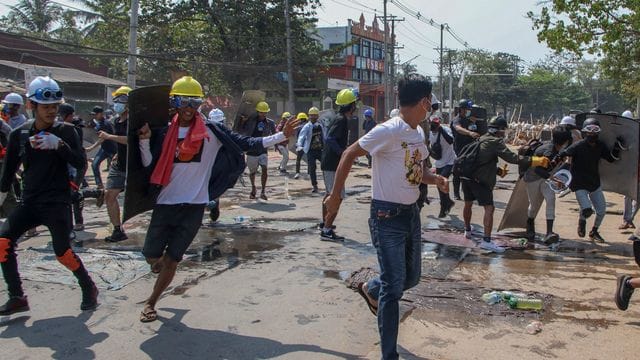 Anti-Putsch-Demonstranten ziehen sich von den behelfsmäßigen Barrikaden zurück, nachdem Bereitschaftspolizisten Schallbomben und Gummigeschosse abgefeuert hatten.
