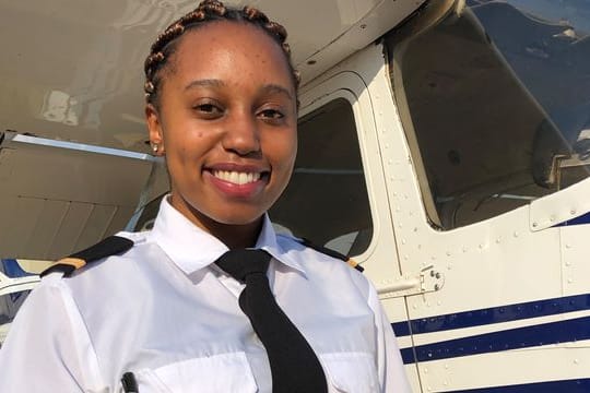 Tshepang Ralehoko steht mit einer Dose mit Keksen vor einer Cessna 172 auf dem Flugplatz Wonderboom.