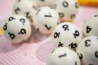 Lotto-Kugeln liegen auf einem Lottoschein: In England hat ein Paar den Jackpot geknackt, dann aber doch kein Geld erhalten.