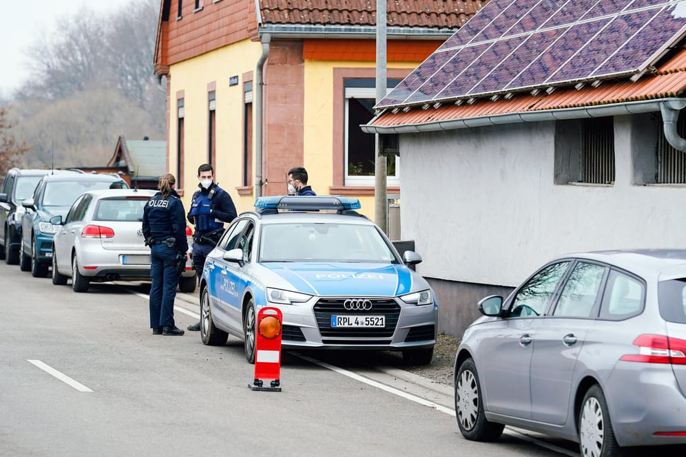Polizisten vor dem Tatort in Weilerbach: Wie lange der Mann mit den Leichen unter einem Dach schlief, ist noch unklar.