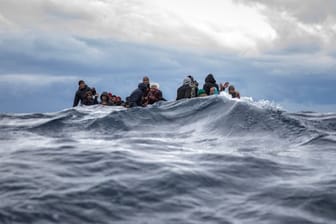 Männer aus Marokko und Bangladesch sitzen in einem überfüllten Holzboot im Mittelmeer vor der Küste Libyens, als sich ihnen Helfer der spanischen Organisation "Open Arms" nähern (Archiv).