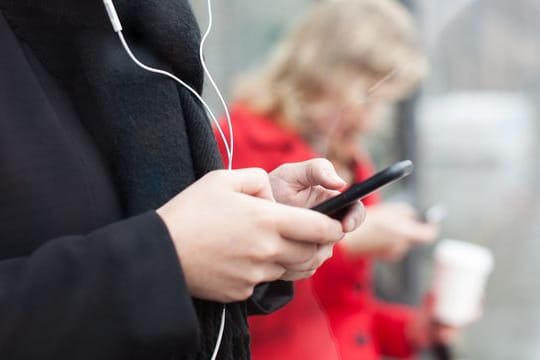 Menschen, die auf Smartphones starren (Symbolbild): Wann wird der Griff zum Handy zur Sucht?