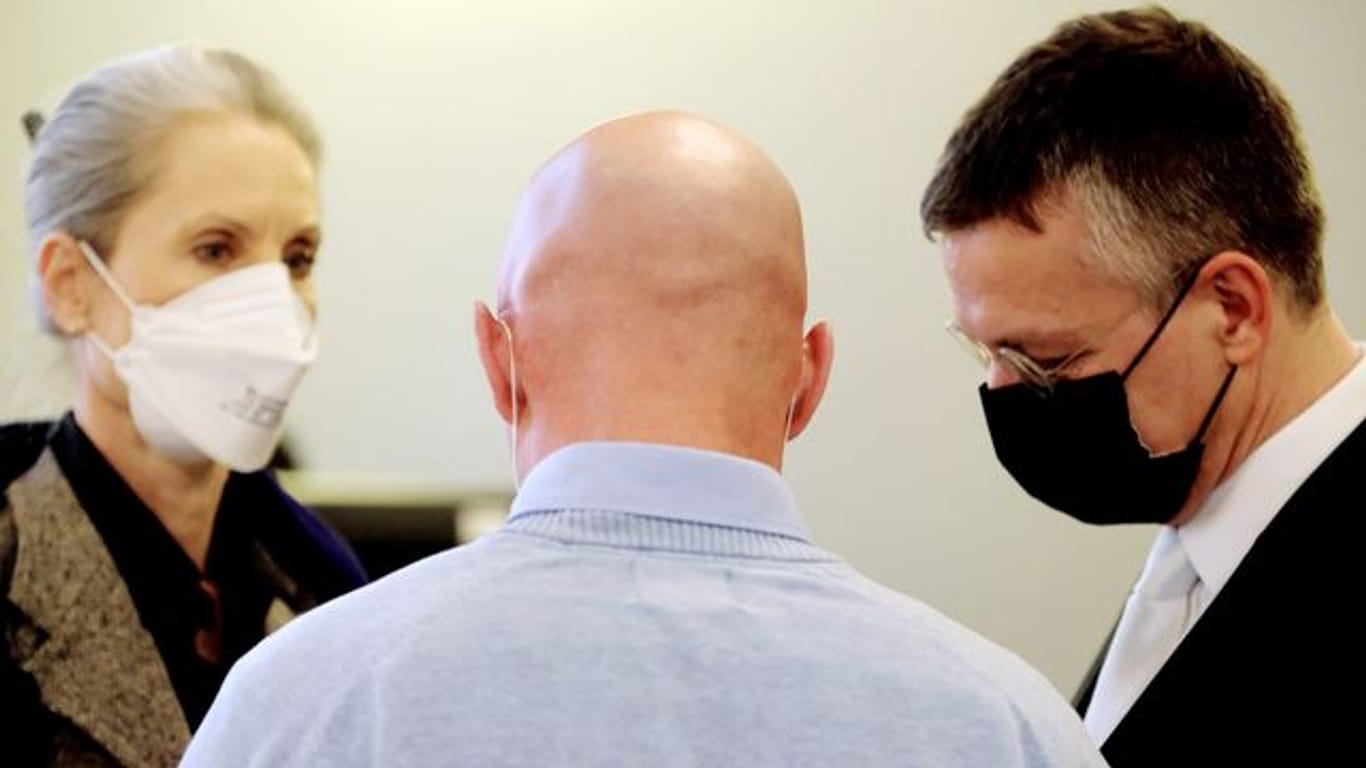 Der Angeklagte (M), ein ehemaliger Bundeswehrsoldat des Kommandos Spezialkräfte (KSK), spricht in einem Saal des Landgerichts mit seinen Anwälten.