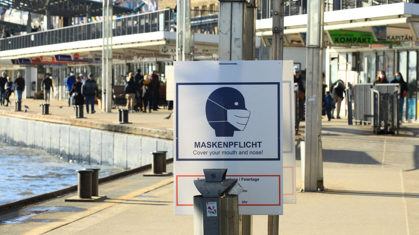 Bei den St. Pauli Landungsbrücken an der Elbe weist ein Schild auf die Maskenpflicht hin: Das Verwaltungsgericht gab einem Eileintrag gegen die Pflicht statt.