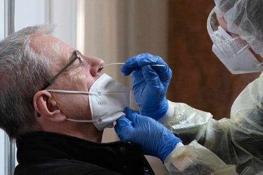 Ein Mann lässt sich im neuen Corona-Testzentrum für Antigen-Schnelltests im Neuen Rathaus in Leipzig testen.