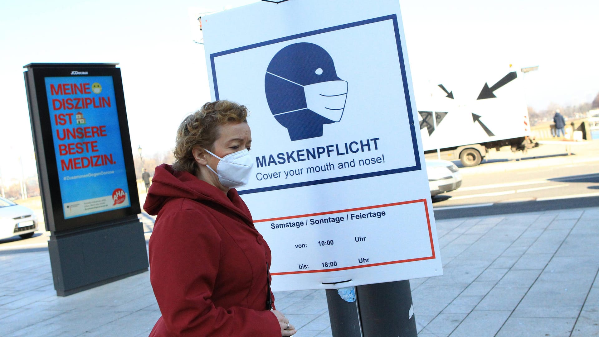 Am Jungfernstieg an der Alster in Hamburg weisen große Schilder auf die Maskenpflicht hin.