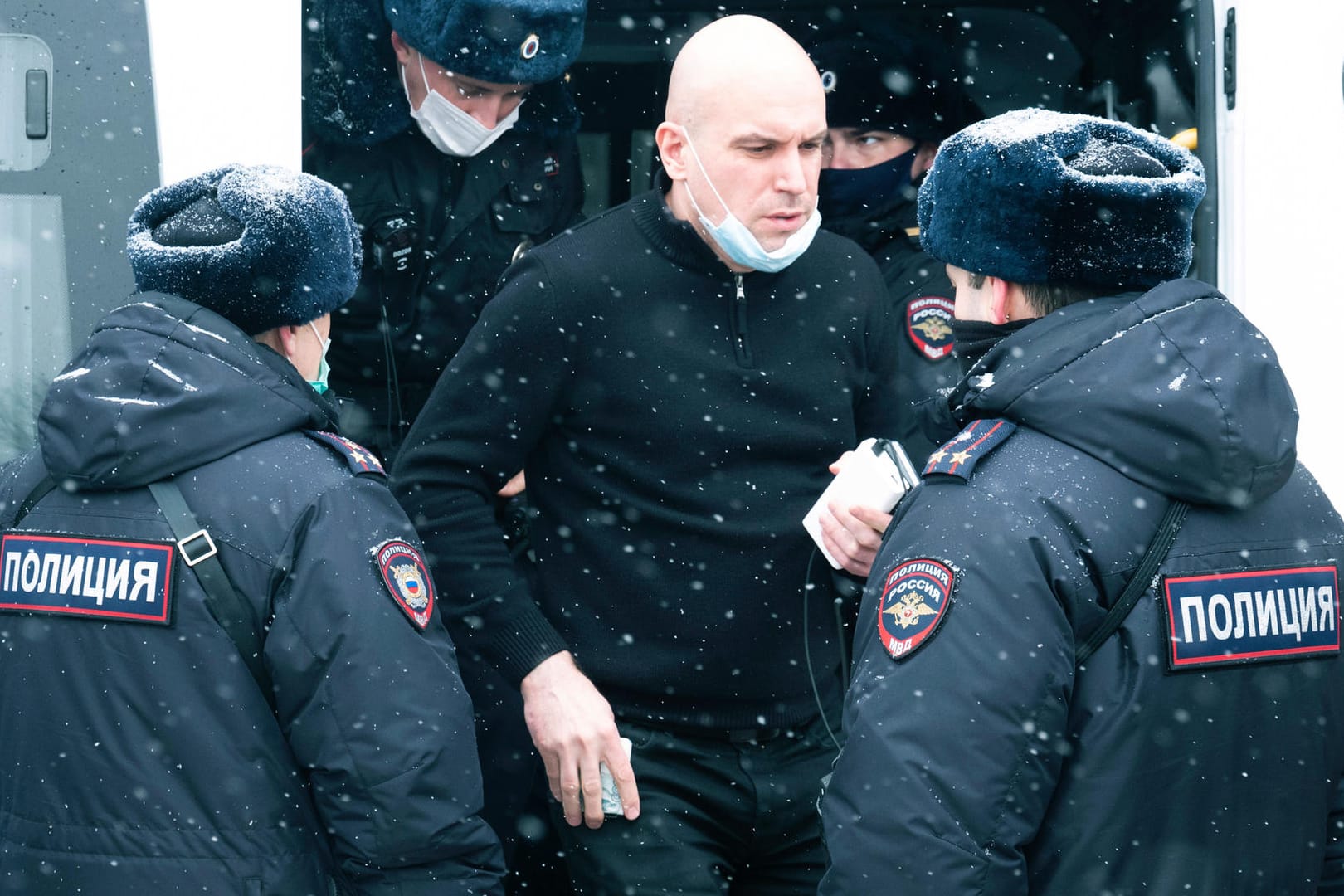 Polizisten umringen einen Mann nach seiner Festnahme in einem Moskauer Hotel: Dort hatte die Opposition über Strategien für ein Russland ohne Putin beraten.