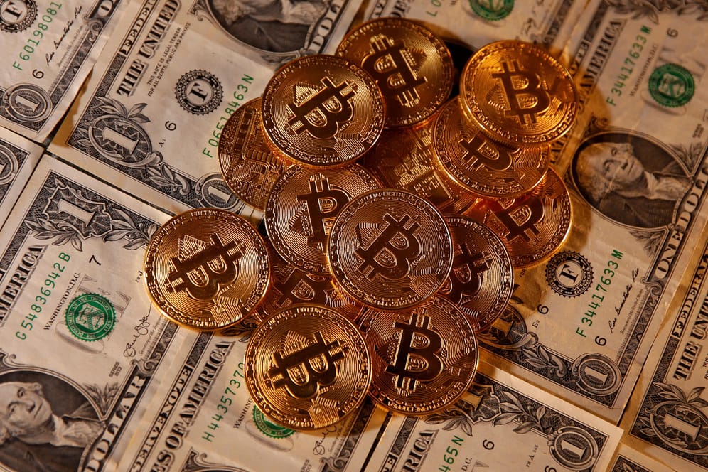 Physische Bitcoin-Münzen auf Dollar-Scheinen: Die Digitalwährung setzt ihre Kurs-Rallye fort.