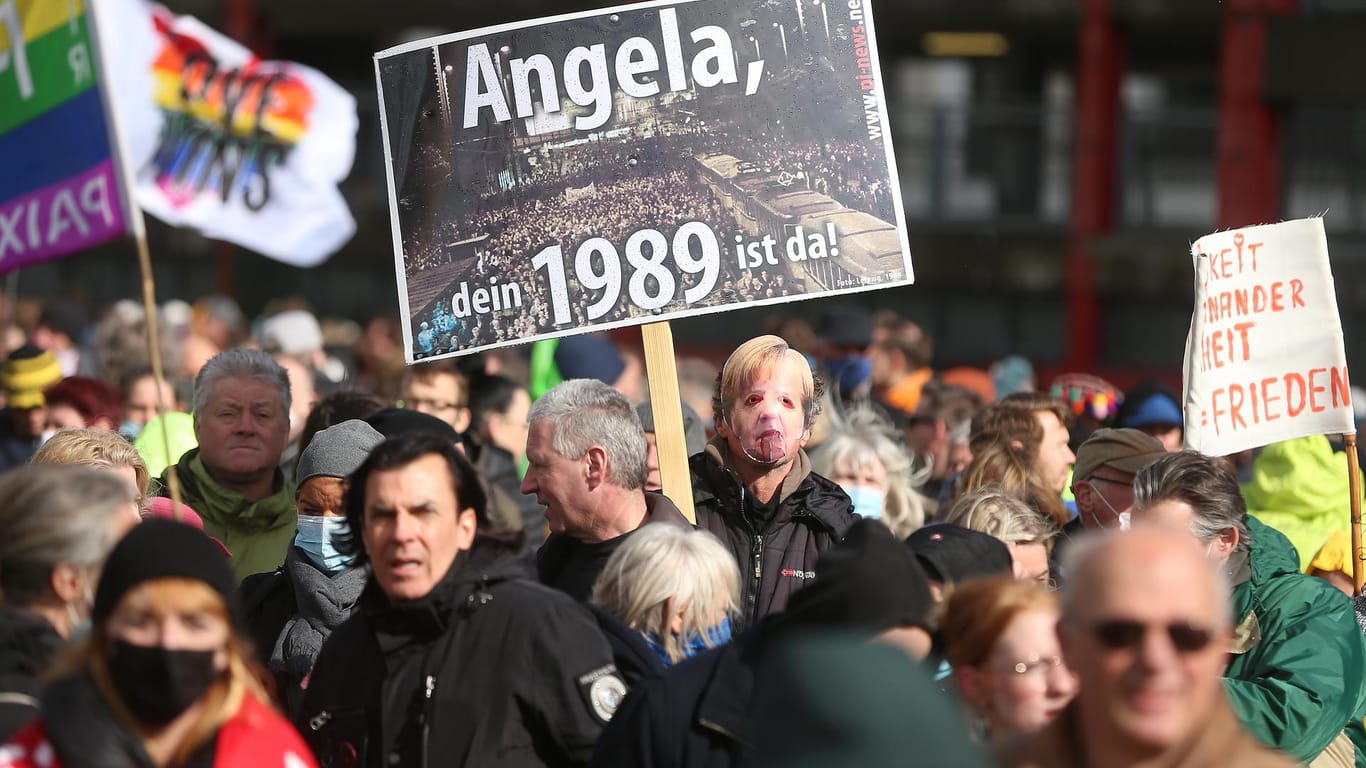 Teilnehmer einer Demonstration protestieren mit Schildern und Fahnen gegen die Corona-Einschränkungen vor dem Düsseldorfer Landtag. Die Veranstaltung sollte Teil der bundesweiten Demonstrationen "1 Jahr Lockdown - es reicht!" sein.
