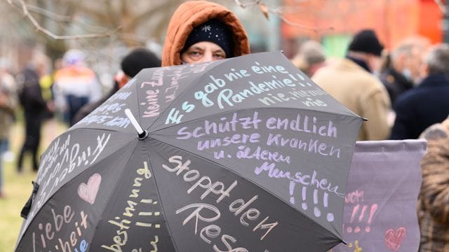 Eine Teilnehmerin der Proteste in Dresden hat ihre Forderungen auf einen Regenschirm geshrieben.