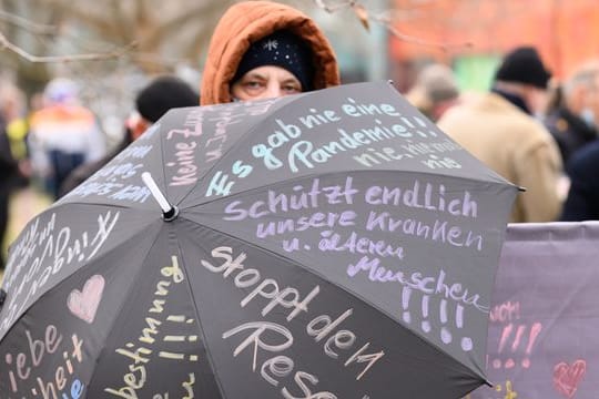 Eine Teilnehmerin der Proteste in Dresden hat ihre Forderungen auf einen Regenschirm geshrieben.