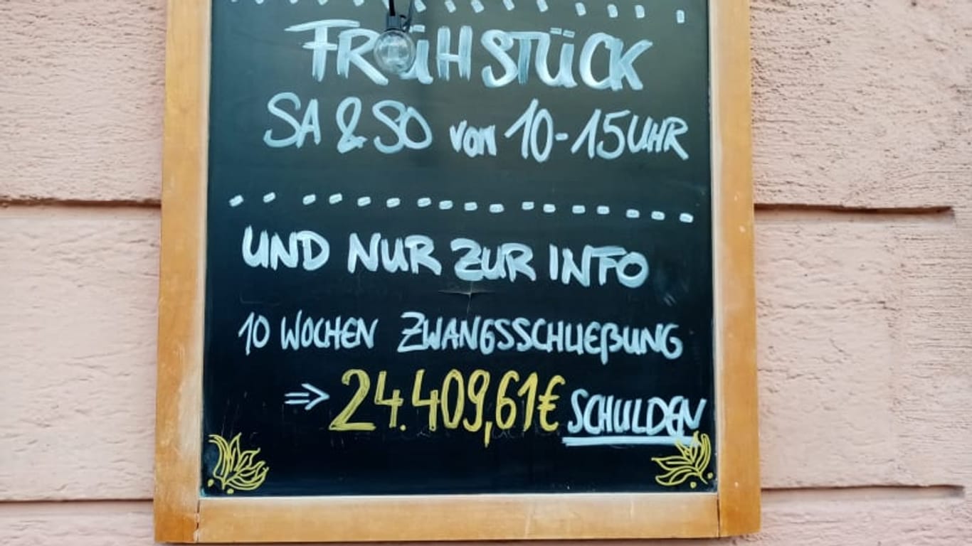 "24.409,61 Euro Schulden" steht auf einer Tafel: Die Inhaberinnen des "Mucki&Floyd" im Münchner Glockenbachviertel haben ihre Schulden öffentlich gemacht.