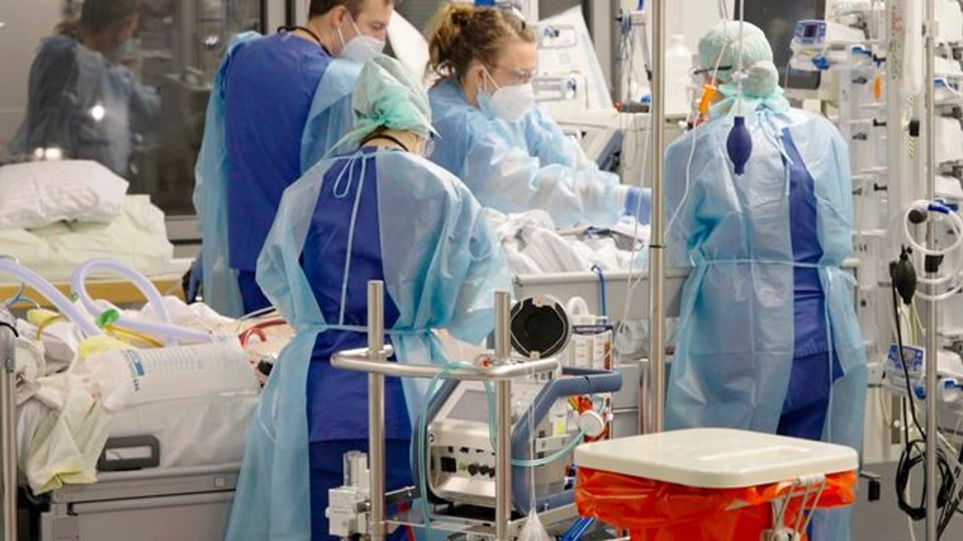 Ärztinnen, Ärzte und Pflegende arbeiten auf der Corona-Intensivstation der Charité am Bett einer jungen Patientin.