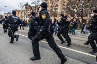 Polizisten rennen auf der Maximilianstraße in München: Bei den Corona-Demos in der bayerischen Landeshauptstadt gab es Dutzende Anzeigen.