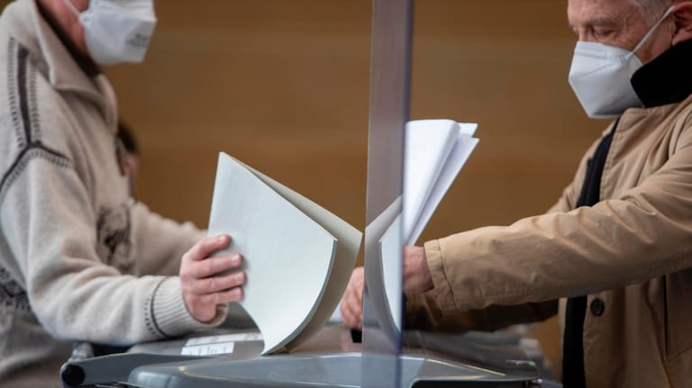 Ein Wähler wirft seinen Wahlzettel bei der Kommunalwahl in Frankfurt in die Urne: "Wir berechnen einen Faktor für die Briefwähler mit ein".