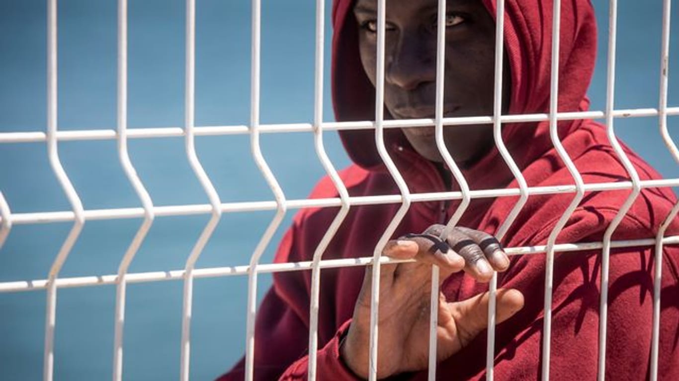 Ein Flüchtling steht an einem Zaun im Hafen von Algeciras.