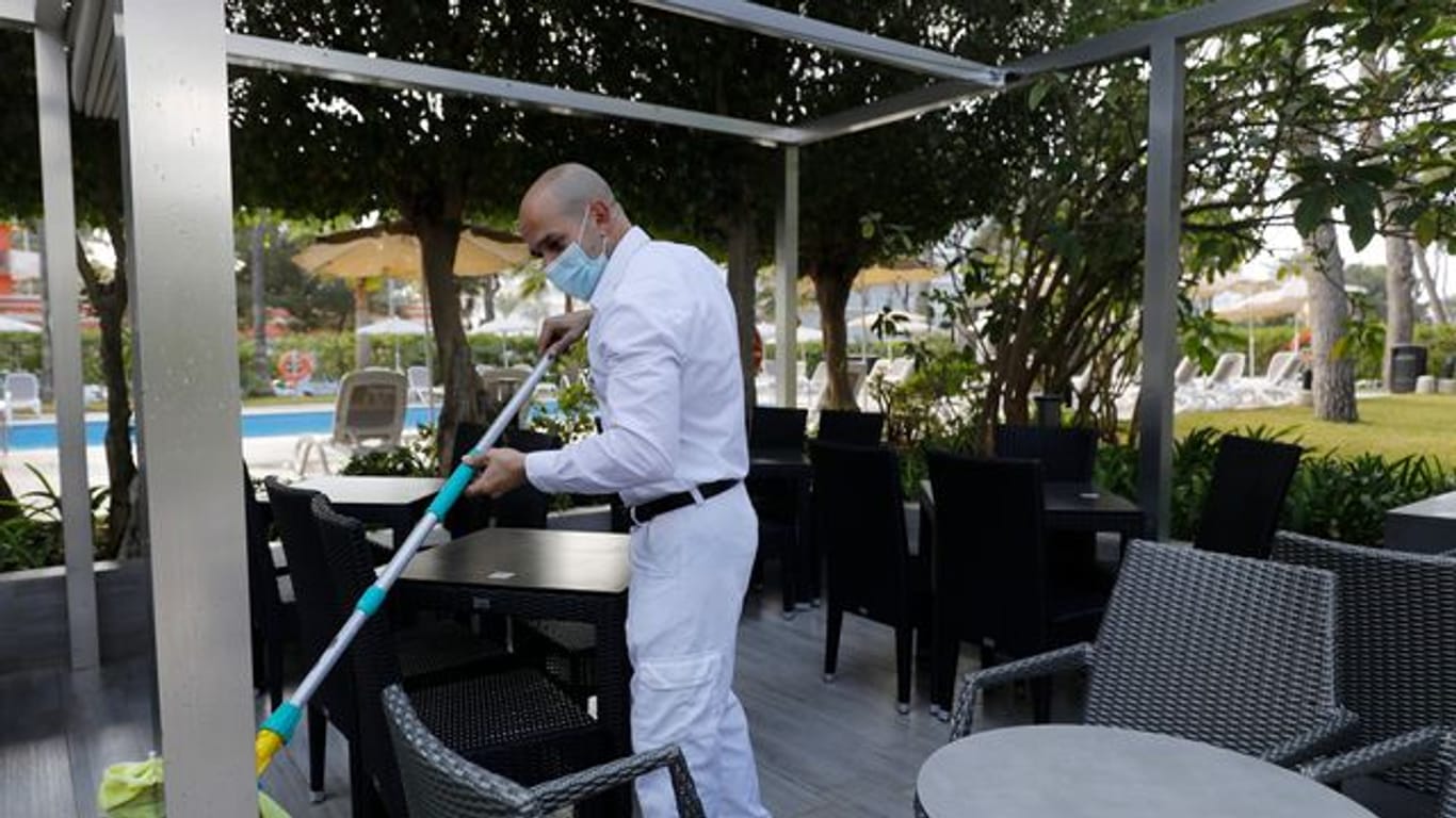 Ein Arbeiter reinigt die Terrasse des Hotels Riu Festival in Palma de Mallorca.